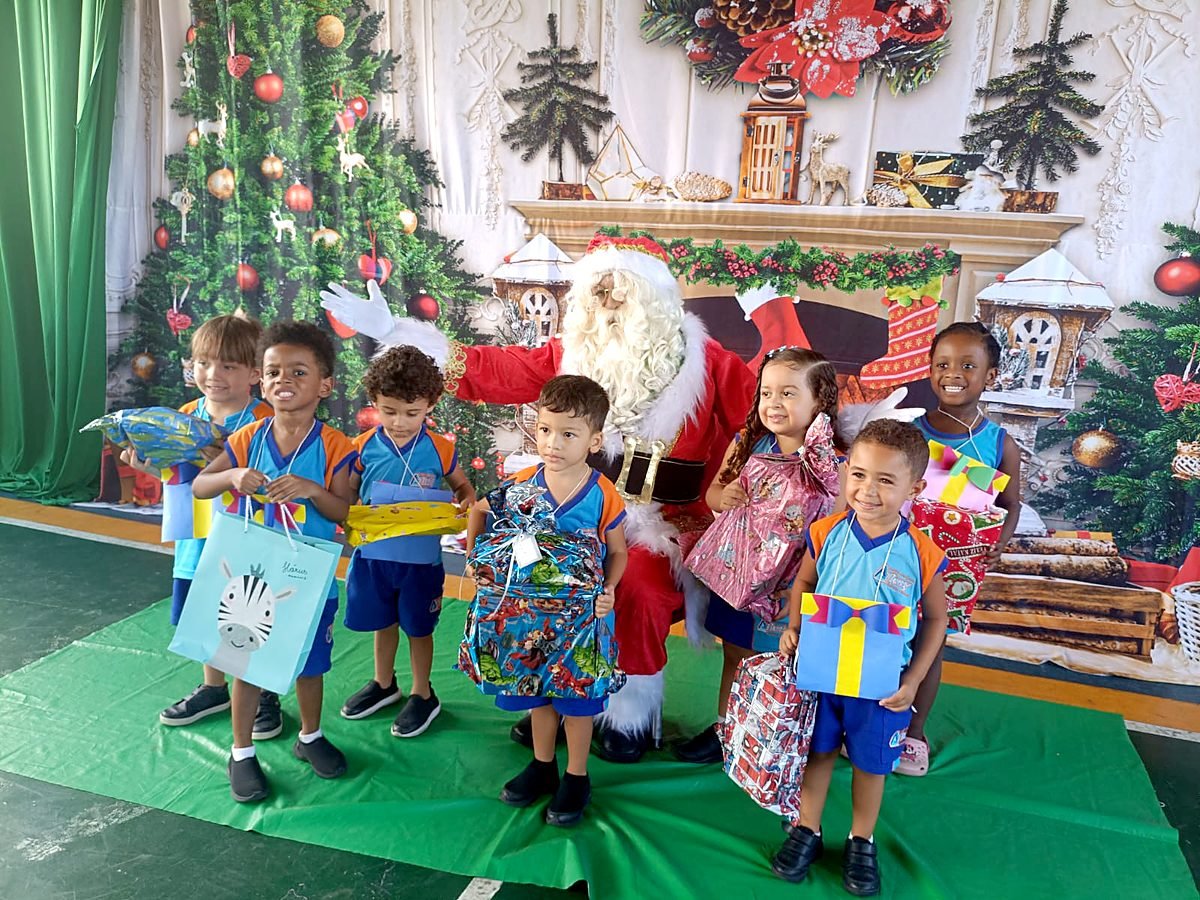 Papai Noel com alunos e presentes na escola