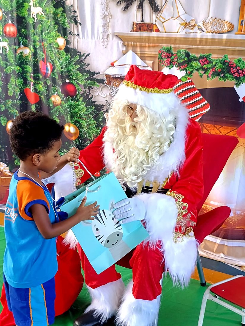 Papai Noel entregando presente a um menino